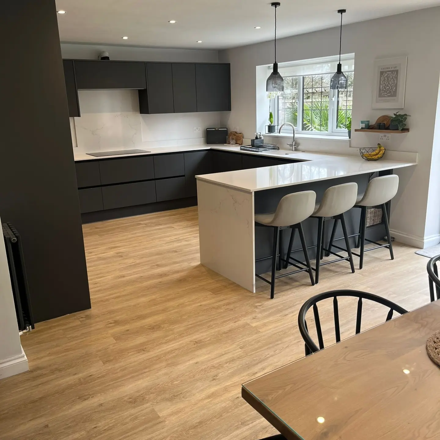 Renovated kitchen with graphite handleless units and a quartz peninsula